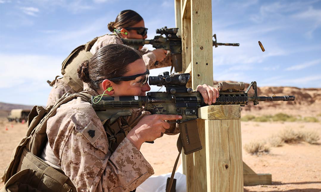 Female service members firing weapons