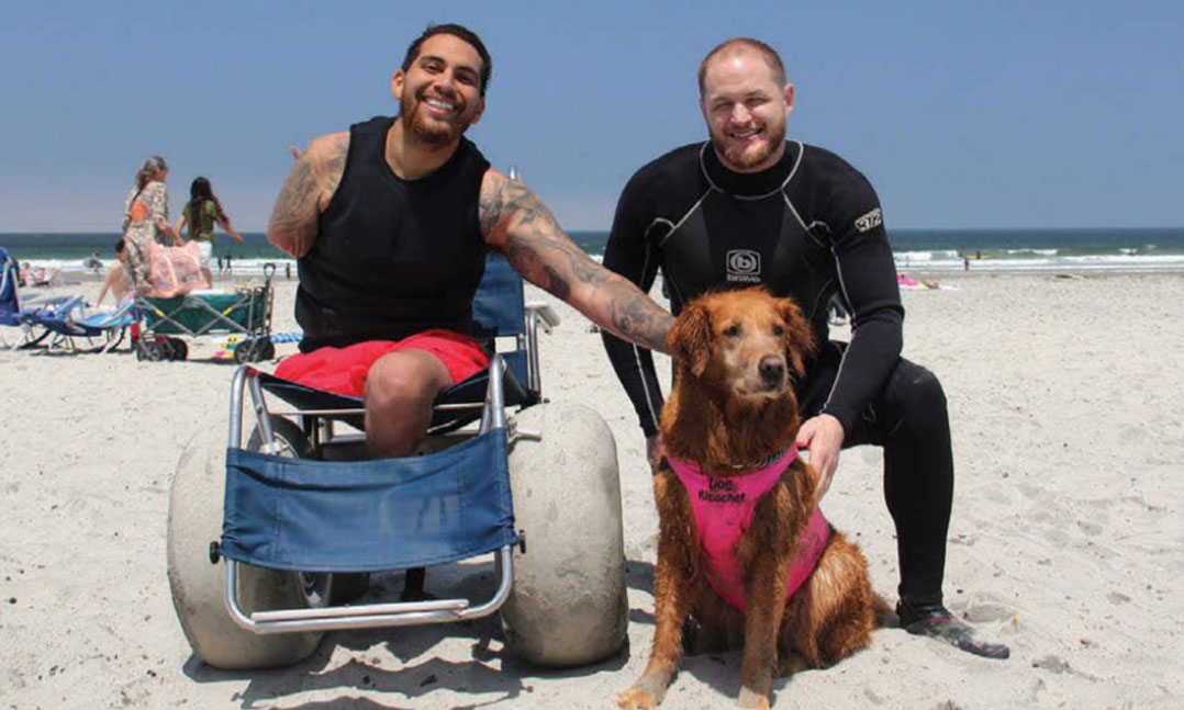 Two wounded warriors enjoy the beach with therapy dog Ricochet