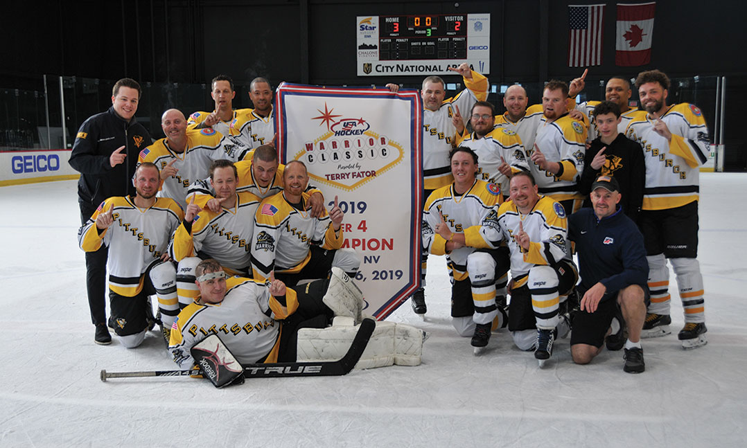 Members of the Pittsburgh Warriors wounded veterans hockey team pose on the ice after winning the 2019 Tier IV Warrior Classic title game