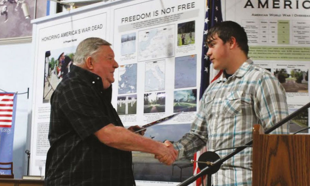 Veteran shaking hands with a high school student