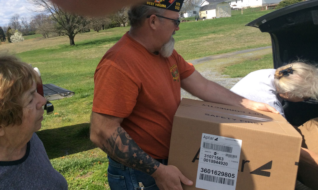 volunteers load up a trunk with donations