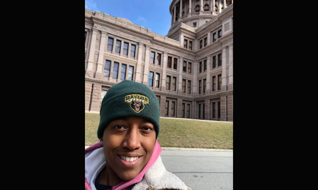 A student veteran in front of her school