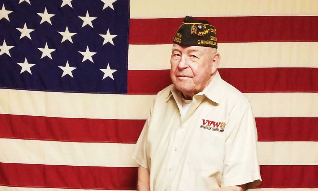 VFW member standing in front of the flag