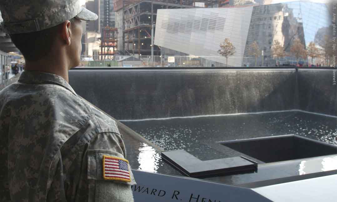 Soldier in uniform stands in front of the World Trade Center Memorial