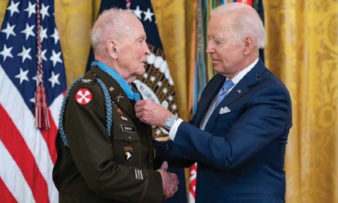 President Joe Biden places the Medal of Honor around the neck of retired Army Col. Ralph Puckett on May 21 at the White House