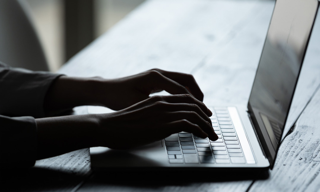 hands typing on laptop