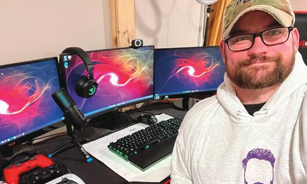 Former Vermont Army National Guardsman and Afghanistan War veteran Alex Black sits at his gaming desk