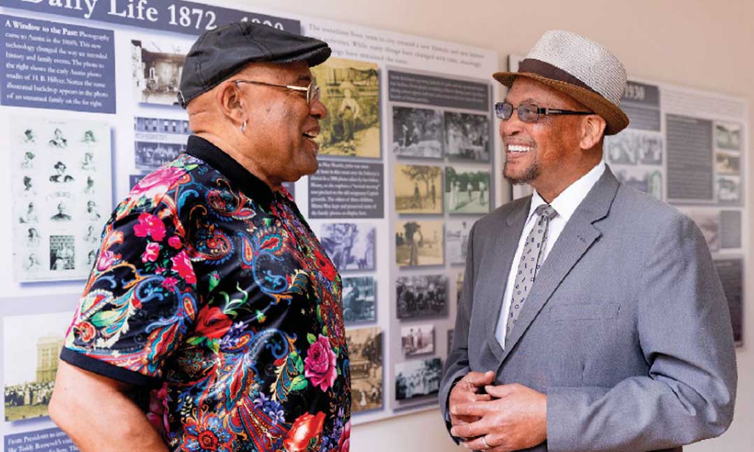 Two men talking in front of an art exhibit