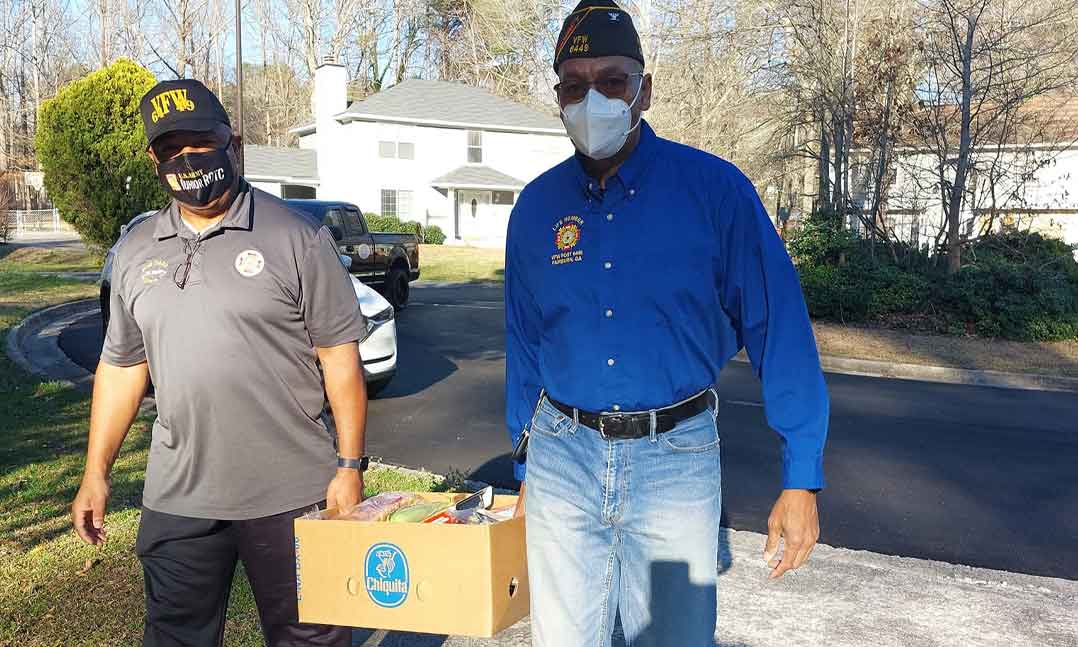 Two VFW members carry donations to veterans in need