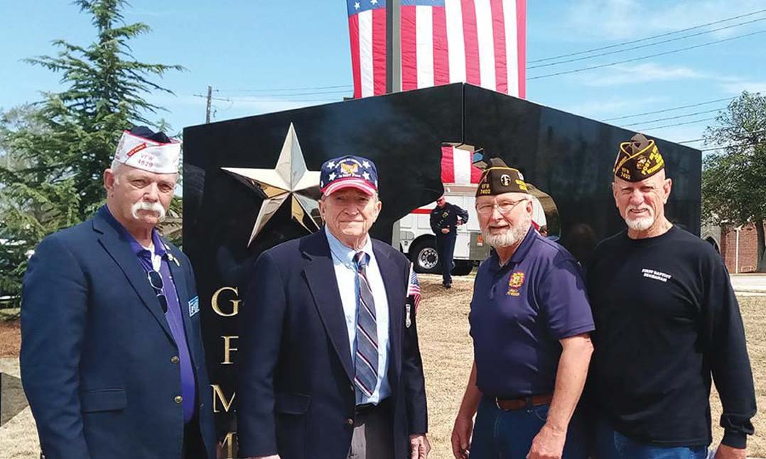 VFW members stand in front of a Gold Family Memorial