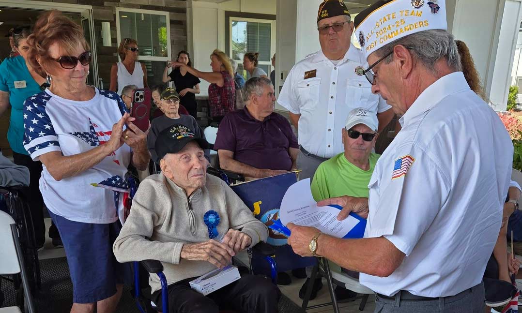 VFW Post 10804 Commander Bob Sedelow (right, standing) reads a VFW Commander-in-Chief Special Citation of Recognition to WWII veteran Gus Preno (sitting)