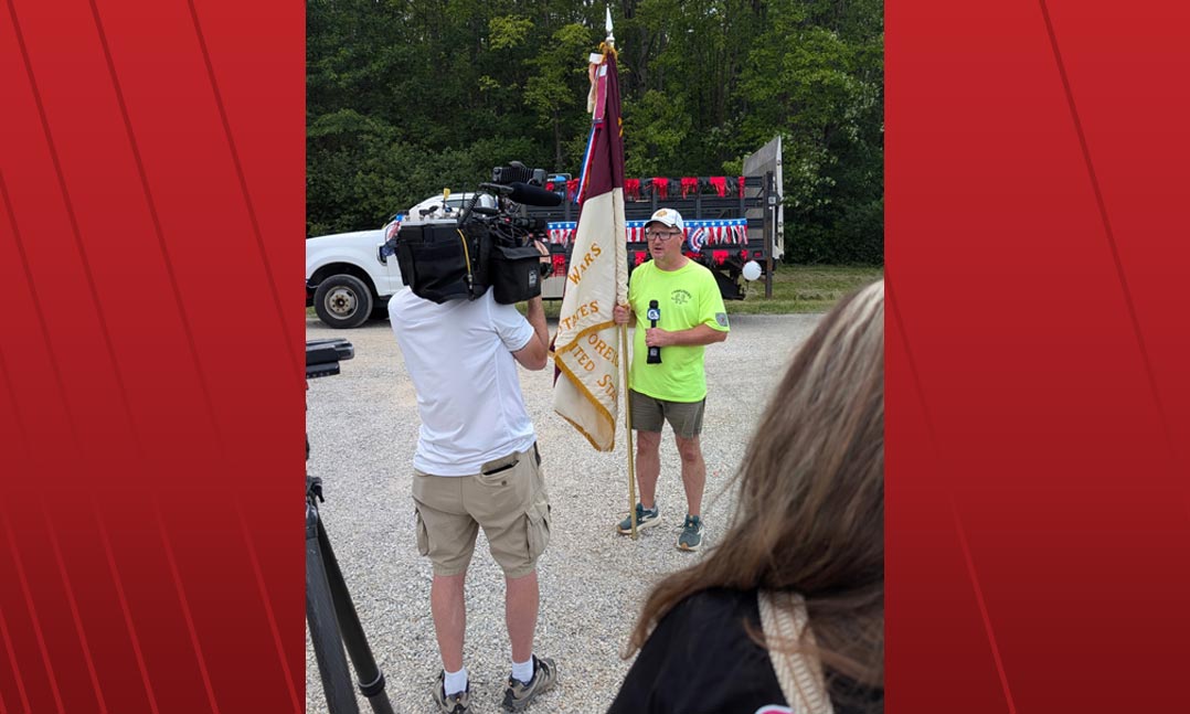 Michael Romans takes time for an interview from a local news station during one of his many walks across northeast Ohio 