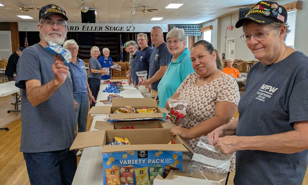 VFW Post 1142 members and its Auxiliary members work together to fill a total of 618 bags with food and personal hygiene items for active-duty military personnel