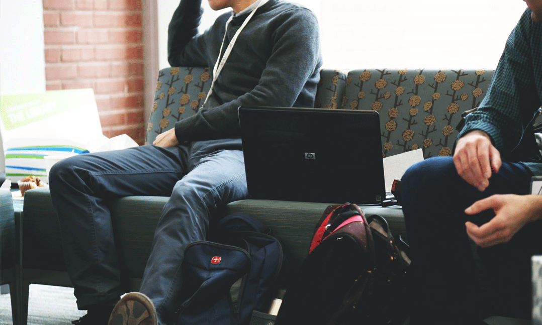 College Students with Backpacks Sitting on a Bench