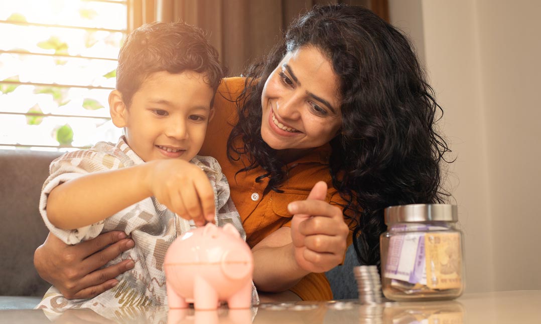 Mom with son putting coins in a piggy bank